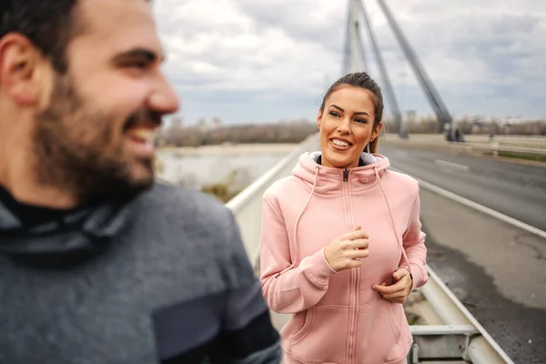 Gülümseyen Mutlu Sportif Çift Bulutlu Bir Havada Sonbaharda Köprüde Koşuyor — Stok fotoğraf