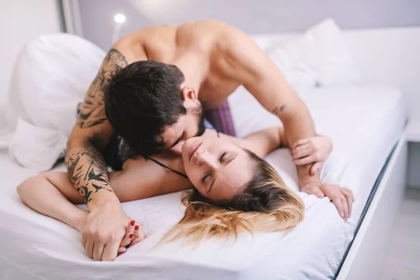 Young attractive caucasian couple making love in bedroom.