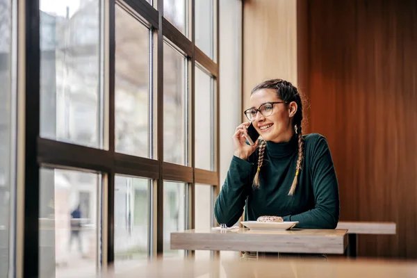 Усміхнена Жінка Сидить Кафетерії Дивлячись Нерівне Вікно Розмовляючи Телефону Глобальна — стокове фото