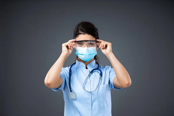 Jovem Médica Dedicada Com Máscara Protetora Colocando Óculos Proteção Surto — Fotografia de Stock