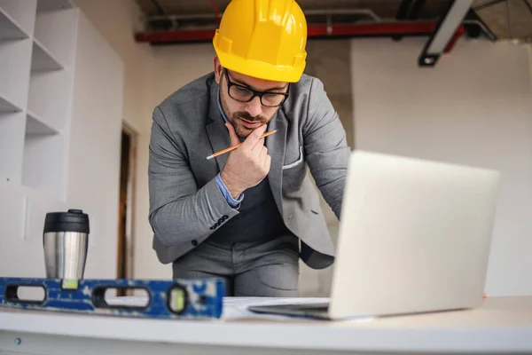 Arquitecto Enfocado Mirando Planos Pensando Mientras Apoya Escritorio Sitio Construcción —  Fotos de Stock