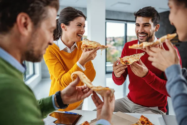 役員室に立ち 昼食のためにピザを食べるビジネスの人々の興奮多文化グループ — ストック写真
