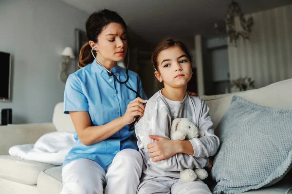 Dokter Duduk Sofa Sebelah Gadis Itu Dan Memeriksa Paru Parunya — Stok Foto