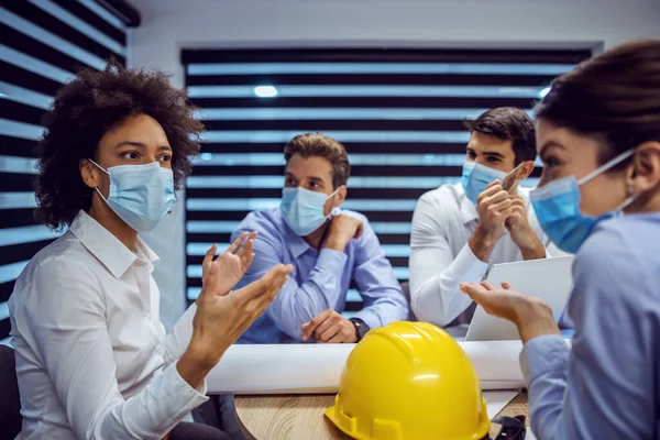 마스크를 그룹의 건축가들이 회의실에 앉아서 코로나 바이러스를 사용하는 동안새로운 프로젝트에 — 스톡 사진
