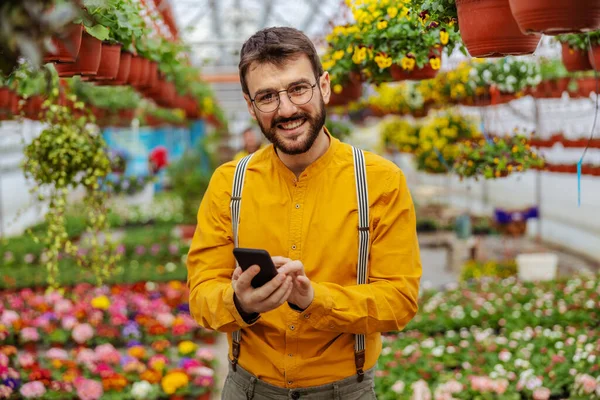Usmívající Zahradník Stojící Skleníku Přijímající Objednávky Zákazníka Přes Chytrý Telefon — Stock fotografie