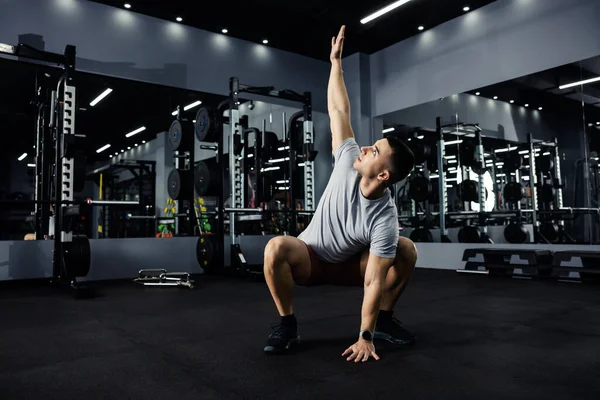 Gri Spor Giyimli Atletik Bir Adam Karanlık Bir Spor Salonunda — Stok fotoğraf