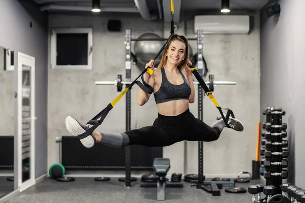 空気中でストレッチの現代的な概念 空気中の体のバランス スポーツウェアと良い物理的な形状のフィット女性はTrx上の筋肉を伸ばします 強い体と強力な近代的な運動 — ストック写真