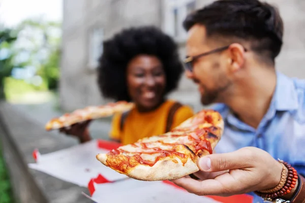 屋外に座ってピザを食べる若い多文化ヒップスターカップルの閉鎖 人間の手に焦点を当て — ストック写真