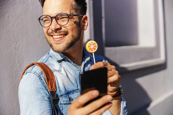 Muda Tersenyum Hipster Berdiri Luar Ruangan Dan Menjilati Lollypop Sambil — Stok Foto