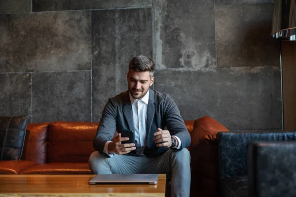 Businessman Sitting Couch Unique Modern Space Using Phone Laptop Technologies — Stok Foto