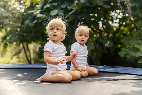 Chicas Trampolín Lindos Bebés Trajes Bebé Blancos Están Jugando Patio — Foto de Stock