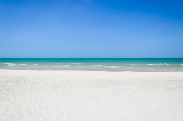 ชายหาดที่สวยงามและทะเลเขตร้อนที่มีท้องฟ้าสีฟ้า — ภาพถ่ายสต็อก