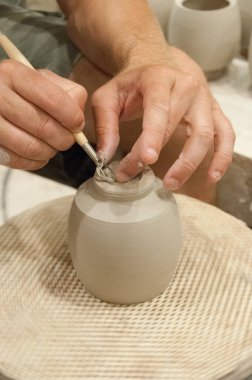 Bir çömlekçi yaptığı vazoyu buduyor.