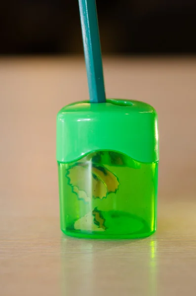 Grüner Bleistiftspitzer, der den grünen Bleistift spitzt — Stockfoto