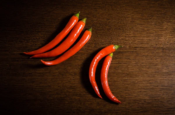 kahverengi ahşap arka plan üzerinde kırmızı biber biber