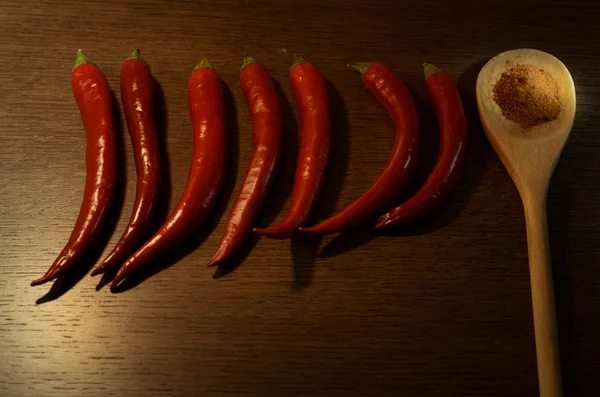 Röd chilipeppar och en trä sked med torr röd paprika — Stockfoto