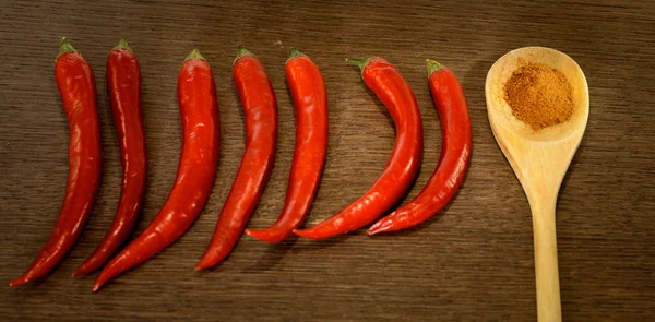 Red chili peppers and a wooden spoon with dry red pepper — Stock Photo, Image