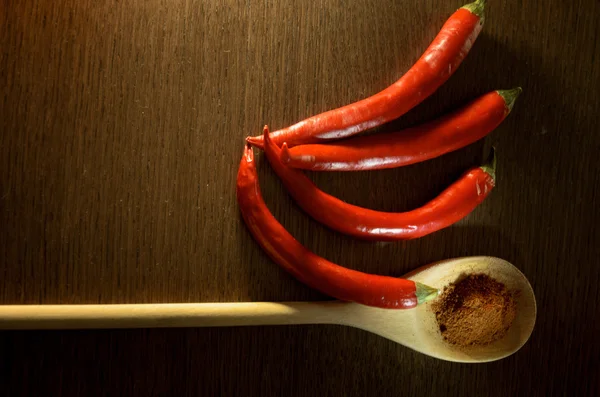 Red chili peppers and a wooden spoon with dry red pepper — Stock Photo, Image