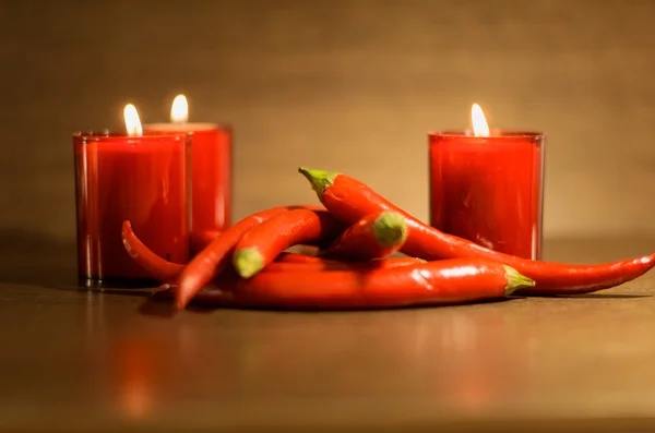Kırmızı biber ve kırmızı yanan mumlar