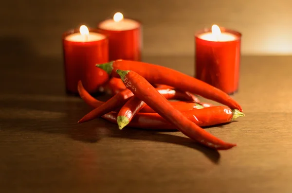 Kırmızı biber ve kırmızı yanan mumlar