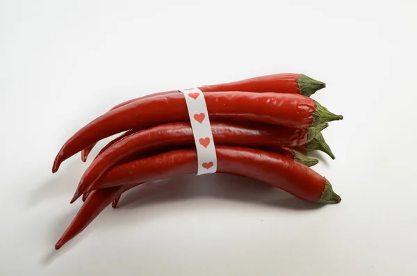 Bunch of red chili peppers tied with ribbon with hearts — Stock Photo, Image