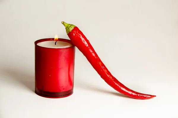 Kırmızı biber ve beyaz zemin üzerine kırmızı mum