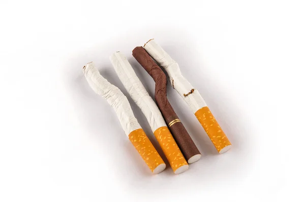 Bent and broken cigarettes on a white background — Stock Photo, Image