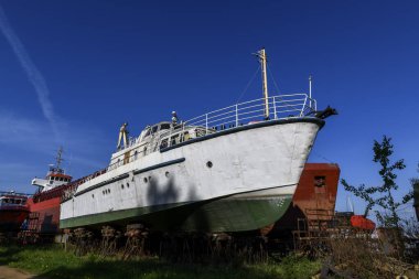Gemi tamirhanesinde küçük bir gemi kıyıya vurmuş. Yaz zamanı..