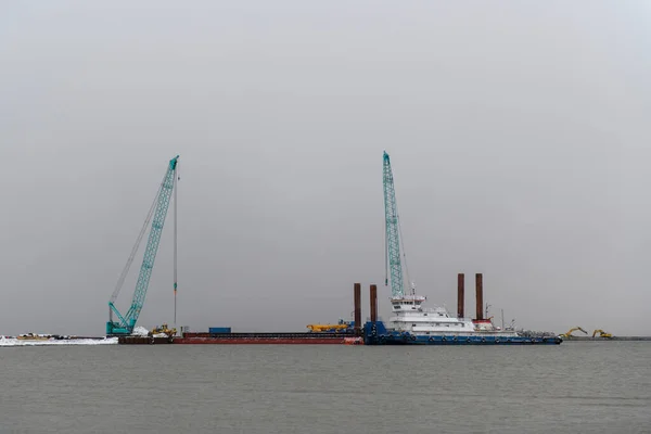 Tug moored to bardge. Construction Marine offshore works. Dam building, crane, barge, dredger.