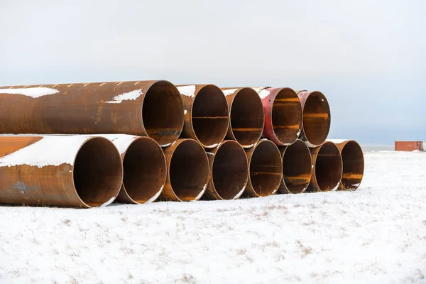 Large tubes in winter tundra. Construction Marine offshore works. Dam building.