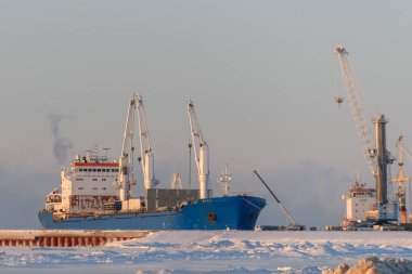 Kargo gemisi Kuzey Kutbu limanına demir attı. Kış zamanı. Buz seyrüsefer. Yükleme devam ediyor.