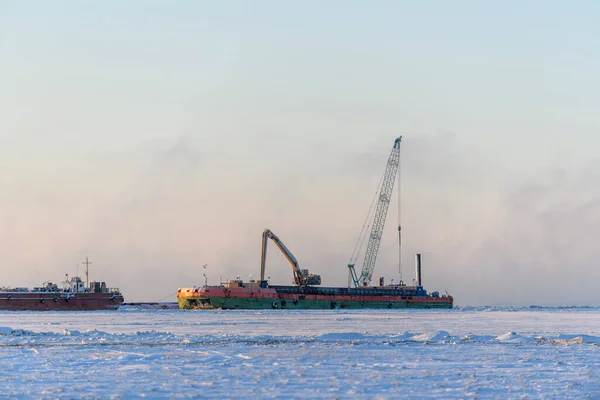 Barge with crane. Dredger working at sea. Sunset in Arctic sea. Construction Marine offshore works. Dam building, crane, barge, dredger.