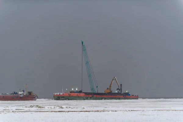 Barge with crane. Dredger working at sea. Strong fog in Arctic sea. Construction Marine offshore works. Dam building, crane, barge, dredger.