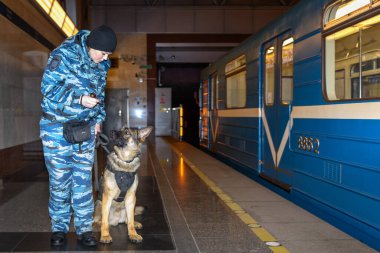 Eğitimli bir Alman çoban köpeği olan kadın polis memuru ya uyuşturucunun kokusunu alır ya da bagajdaki bombayı. Metro istasyonu..