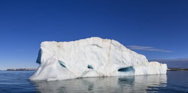 Kutup Denizi 'nde güneşli bir günde güzel bir buzdağı. Denizde büyük bir buz parçası. Yaklaş..