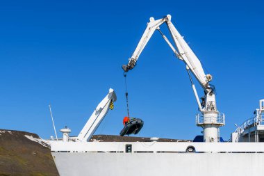 Geminin vincini kullanarak güvertede şöförlü şişme bot yükleniyor. Kuzey Kutup Seferi.