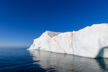 Kutup Denizi 'nde güneşli bir günde güzel bir buzdağı. Denizde büyük bir buz parçası. Yaklaş..