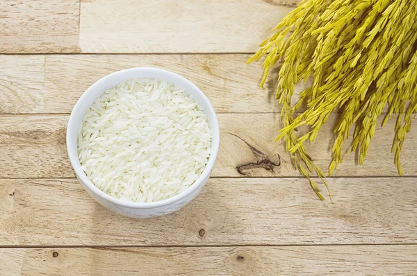 White raw rice and paddy rice of organic jasmine rice on wood background — Stock Photo, Image