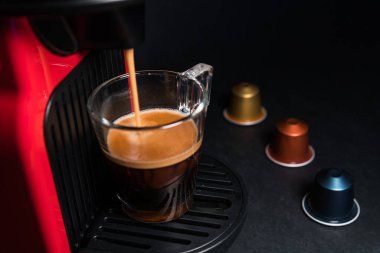 Ev yapımı kahve espresso makinesinin soyut ve kavramsal hali. Siyah arka planda izole edilmiş. Bir fincan kahve ve köpüklü kahve makinesi. Kopyalama alanı olan grafiksel kaynaklar.