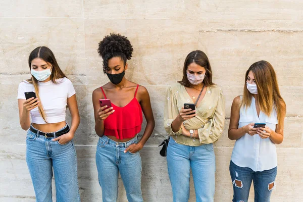 Group only young women multiracial with face mask using smartphone - Group only young girls interracial with face mask using smartphone - Group only young female multiethnic with face mask using smartphone