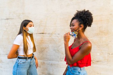 Corona virüsünün yayılmasını önlemek için yüz koruyucu maske takan kadınlar - Coronavirus salgını sırasında genç kadın portresi - Sağlık hizmetleri kadınları ve gençlerin çok ırklı yaşam tarzı arkadaşlık kavramı