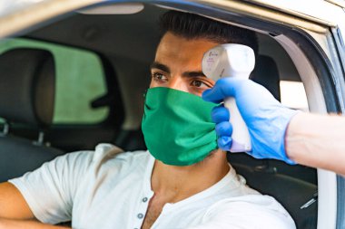 Virüs covid-19 semptomları için vücut sıcaklığını ölçmek için kızılötesi temas olmayan termometre tabancası kullanılıyor.