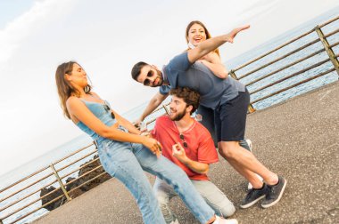 20 'li yaşlarda birlikte eğlenen genç arkadaşların portresi. Açık havada gün batımında açık havada çekim..