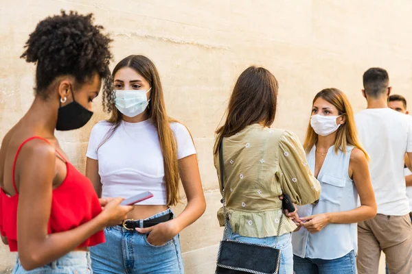 Friends wearing face protective mask to avoid corona virus spread - Young millennial people portrait during coronavirus outbreak - Health care people and youth multiracial lifestyle friendship concept