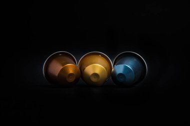 Ev yapımı kahve kapsülü makinelerinin soyut ve kavramsal hali. Siyah arka planda izole edilmiş espresso kahve kapsülleri koleksiyonu. Detaylı yakın çekim görüntüsü. Kopyalama alanı olan grafiksel kaynaklar.