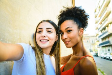 Sokakta selfie çeken iki ırklar arası kadın. Çok ırklı kızlar eğlenin.. 