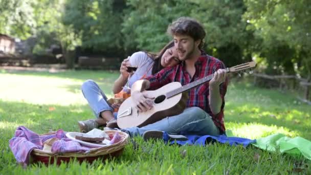 Jovem Casal Caucasiano Dia Ensolarado Toca Guitarra Parque Canta Bebe — Vídeo de Stock