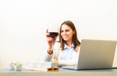 Şarap içen bir kadın, dairesinde oturan bir bardak kırmızı şarabı zevkle yudumlayan genç bir kadın. Kız bir kadeh şarapla rahatlıyor..