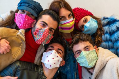 Covid ikinci dalga salgını sırasında kapalı maskeli selfie çeken çok uluslu arkadaşlar, gençlerin birlikte eğlendiği yeni normal yaşam tarzı konsepti, parlak, parlak arka plan ışığı filtresi.