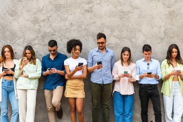 Üniversitenin arka bahçesinde akıllı telefon kullanan çok ırklı arkadaşlar cep telefonu bağımlısı gençler, her zaman milenyuma bağlı teknoloji kavramı, filtre imajı.